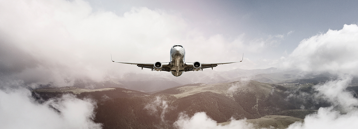 Passenger jet airplane flying above clouds